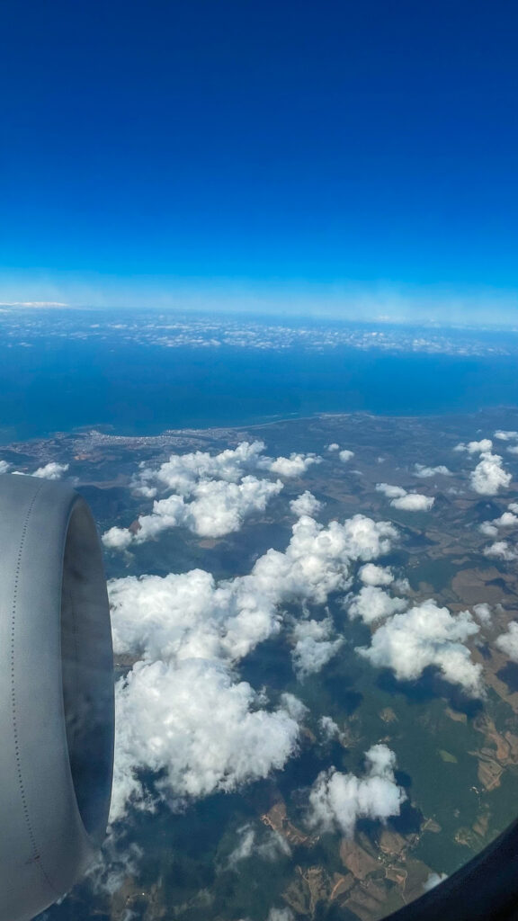 Foto da janela do avião, com nuvens